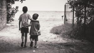 Zwei Kinder laufen Schulter an Schulter einen Weg entlang