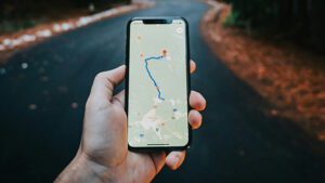 Eine Hand hält ein Smartphone, das eine Route navigiert.