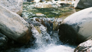 Wasser fließt durch Steine in einem Bach