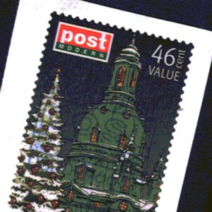 Eine Briefmarke zeigt eine schneebedeckte Tanne und eine grüne Kirche